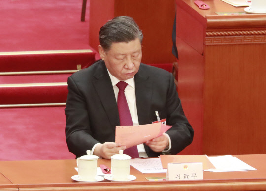 시진핑 국가 주석이 10일 베이징 인민대회당에서 열린 중국 제14기 1차 전국인민대표대회(전인대) 제3차 전체회의에서 국가 주석 등 투표에 앞서 투표용지를 살펴보고 있다. [베이징=연합뉴스]